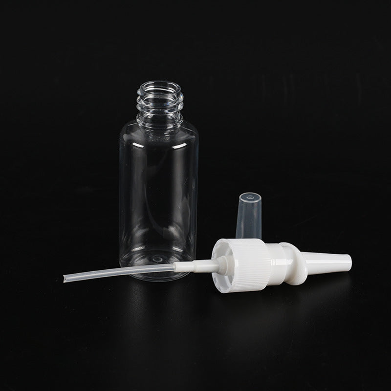 Clear glass bottle with white pump dispenser on a black background